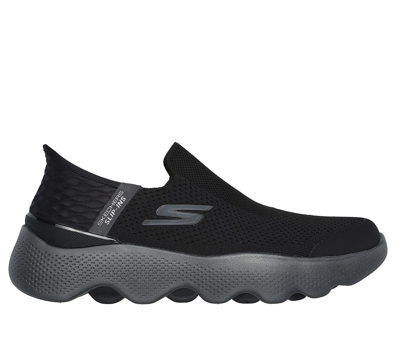 The image shows Skechers men's slip-on footwear captured at an angled side view, highlighting the sleek upper material and cushioned sole. The focus is on the ergonomic design and seamless fit