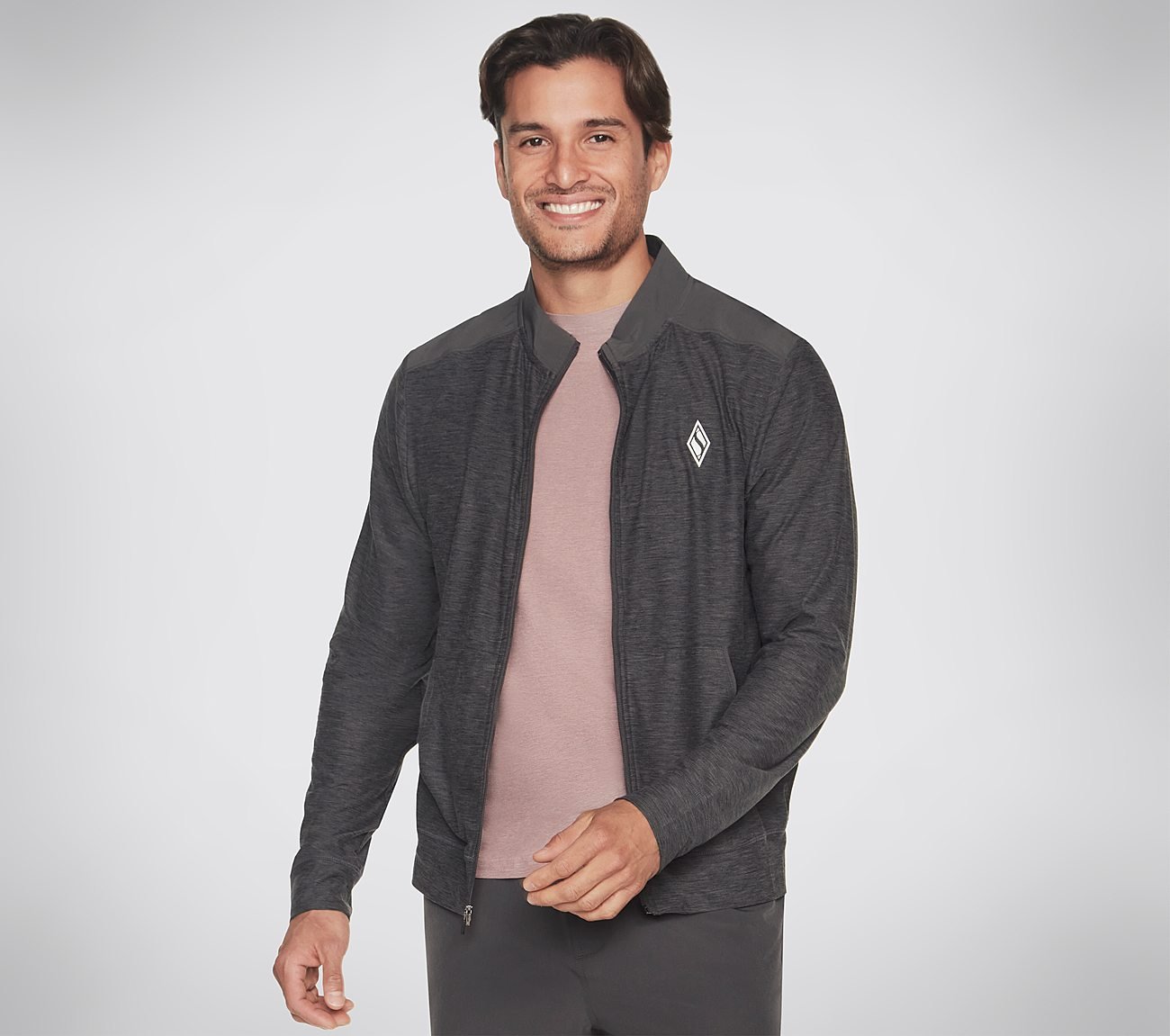 A stylish men’s Skechers Hoodless Ultra Go Jacket shown in a sporty environment with its streamlined design and lightweight material on display