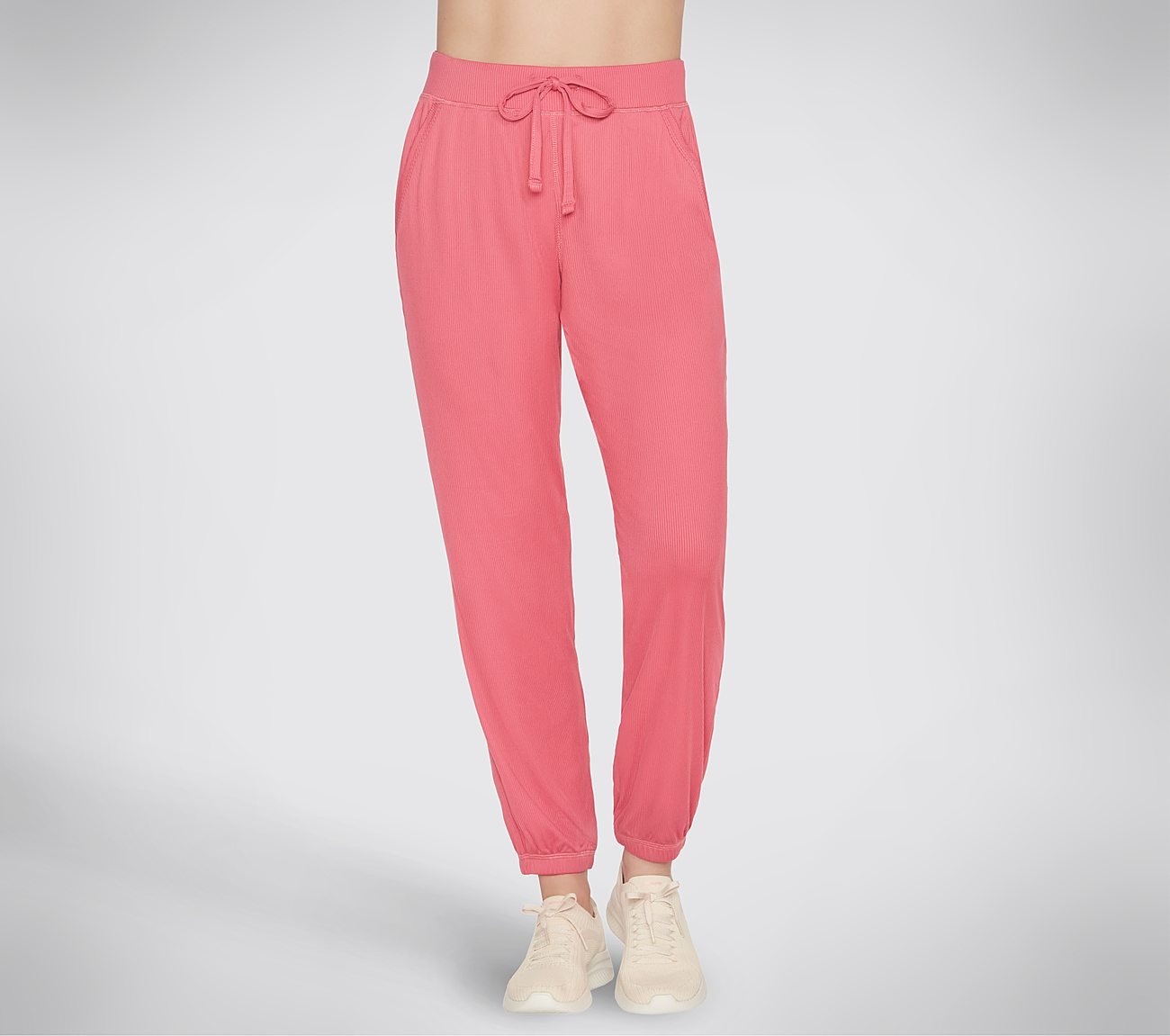 The photo shows a pair of Skechers women’s joggers laid flat to showcase the slim-fit design, elastic waistband, and soft, high-quality fabric. The angle highlights the stitching and sleek cut