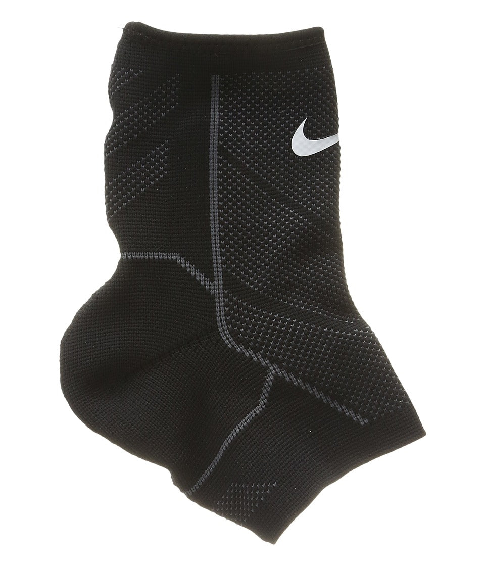 The image shows a unisex Nike ankle sleeve wrapped securely around an ankle, highlighting its supportive and flexible fit.