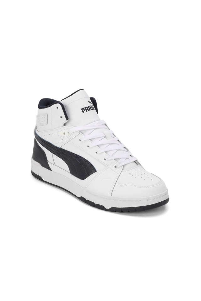 Side angle of the PUMA RBD Game Nova Mid Men Shoe in White-New Navy-PU, showcasing its bold mid-cut design, cushioned sole, and premium detailing.