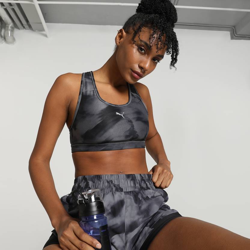 Front view of PUMA Women's Running Bratop, highlighting the racerback design, moisture-wicking fabric, and signature PUMA logo for a sleek, active look.