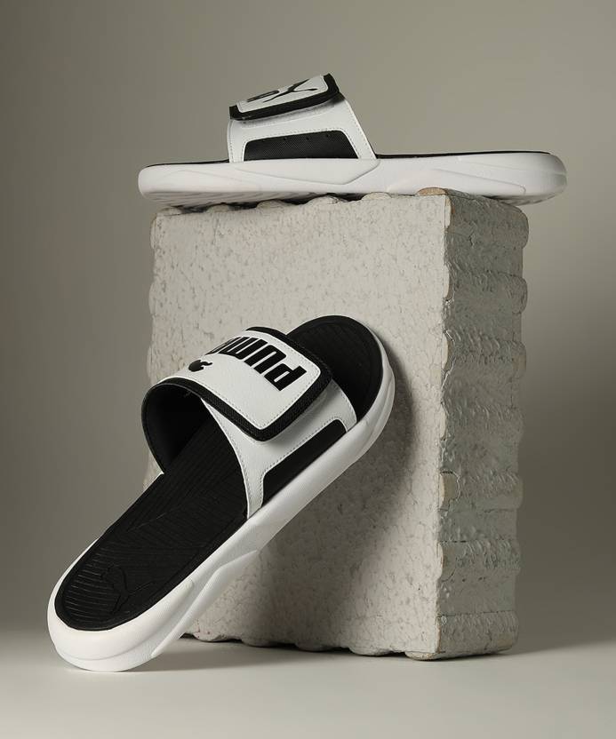 Side view of PUMA Men's Slippers, showcasing the soft plush interior, non-slip outsole, and iconic PUMA logo, designed for comfort and stability during indoor wear.